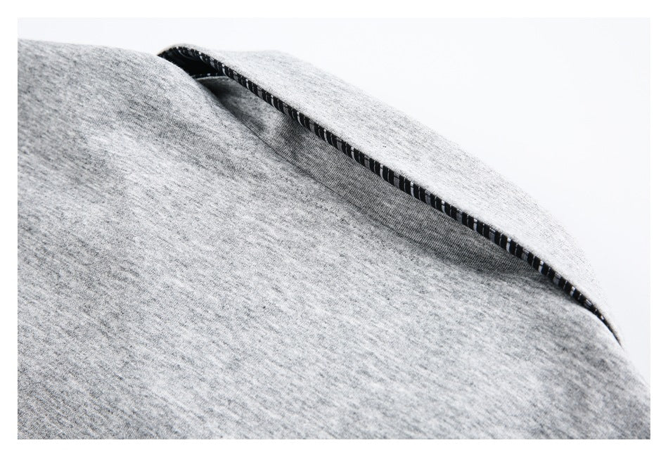 Close-up of light gray heathered fabric edge with black-and-white striped inner stitching.