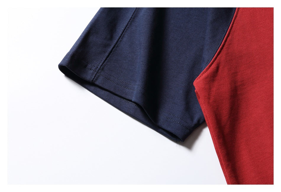 Close-up of a navy sleeve beside the red body of a shirt, showing the double-stitched sleeve hem.