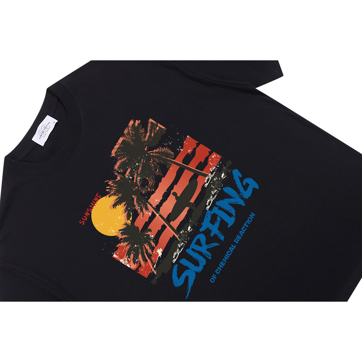 Angled view of a black T-shirt with a colorful sunset, palm tree and surfing graphic.