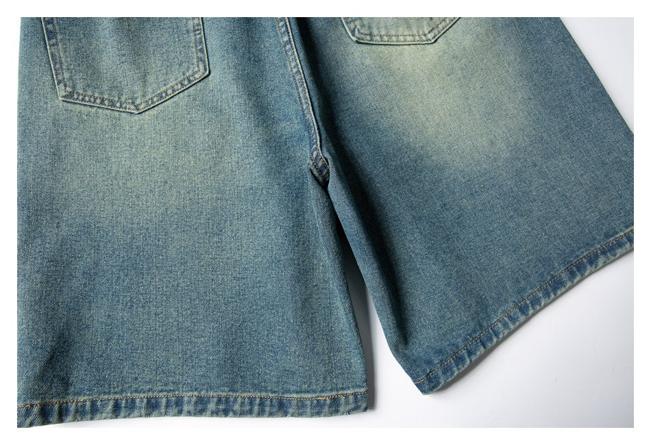 Cropped back view of faded blue denim shorts, showing two patch pockets and wide legs.