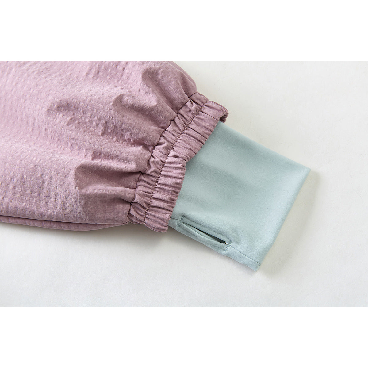 Close-up of the mauve jacket's gathered sleeve cuff over a pale blue inner cuff.