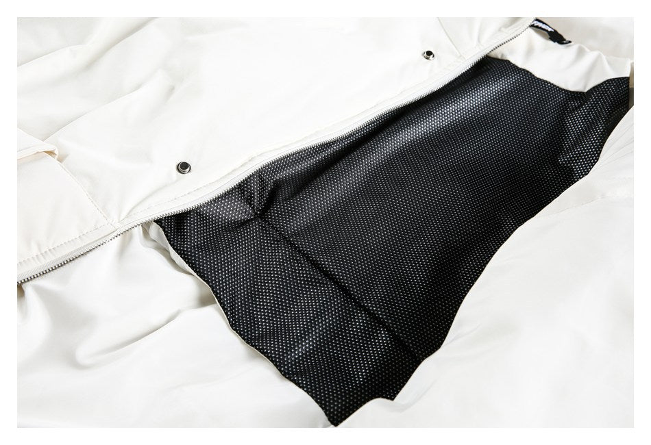 White garment opened to show black dotted lining, a zipper, and metal snap fasteners.