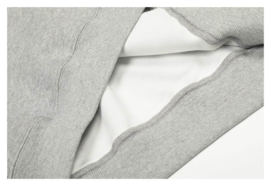 Close-up of the gray sweatshirt's ribbed hem opened to show its light-colored inner side.