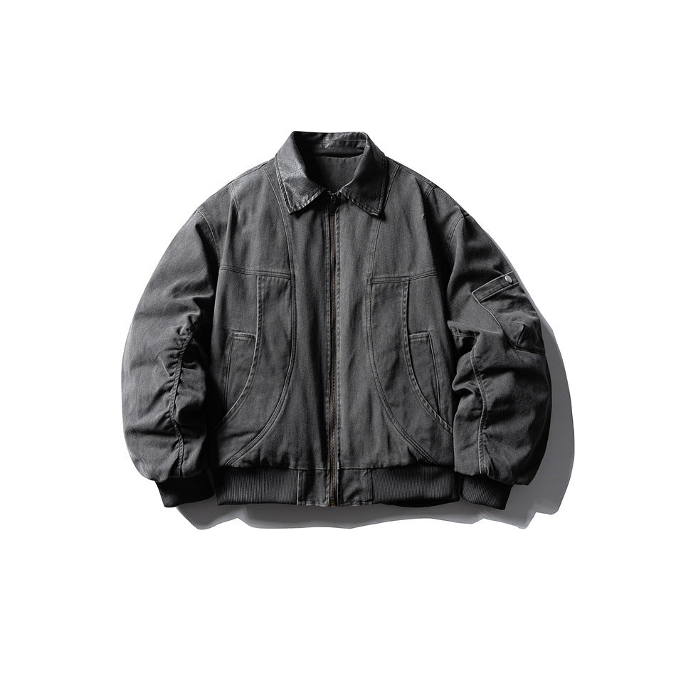 Gray padded bomber jacket with dark collar, front zipper, curved seams and snap sleeve pocket, flat lay