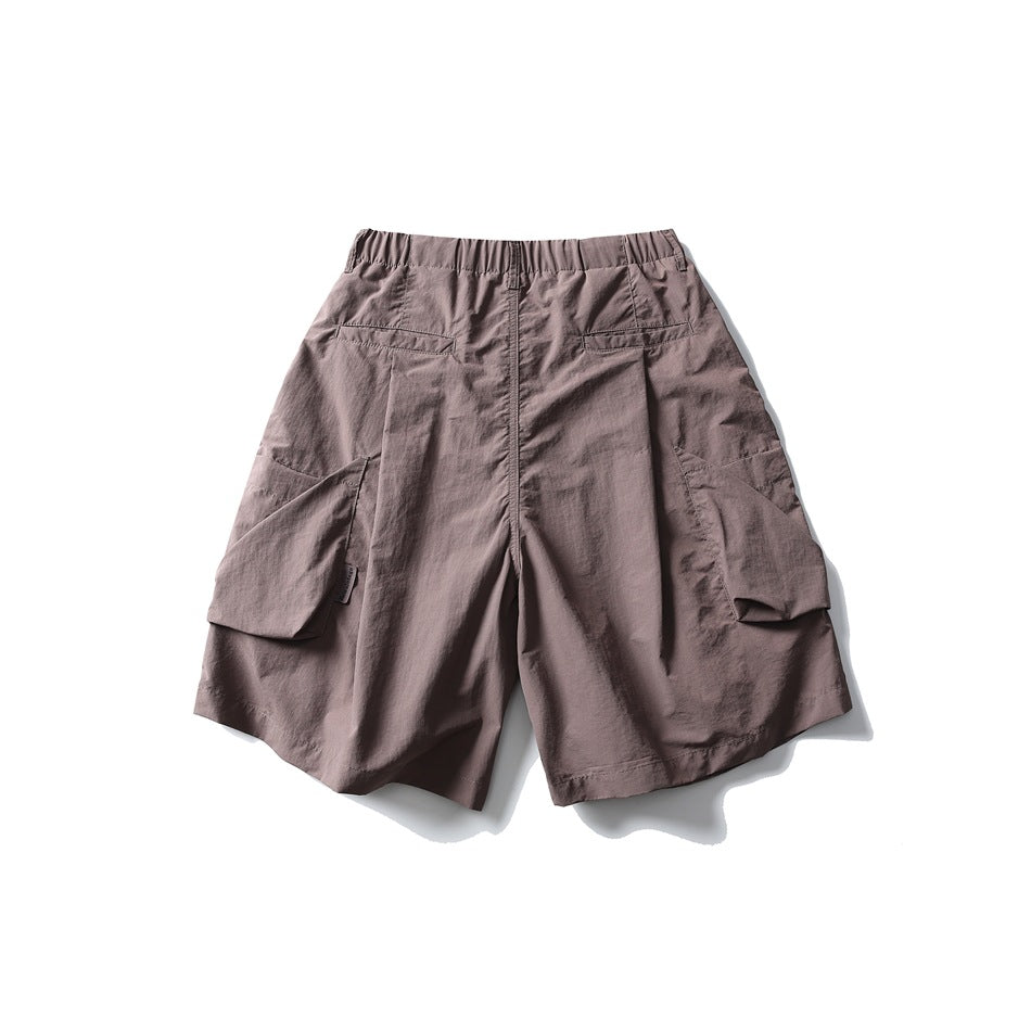 Back view of mauve cargo shorts with an elastic waistband, rear pockets, and large flap side pockets, on white.