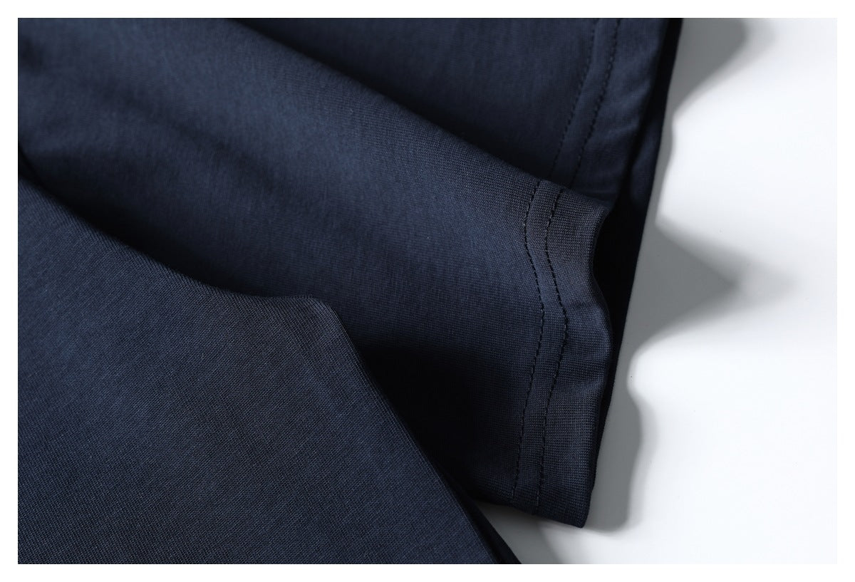 Close-up of a dark navy short sleeve and its stitched cuff lying against a white background.