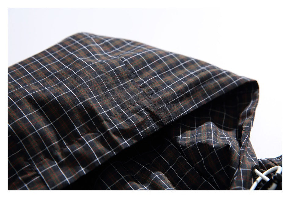 Close-up of the jacket's dark plaid hood and stitched brim.