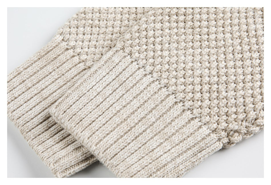 Close-up of the cream sweater's ribbed cuff and chunky knit fabric.