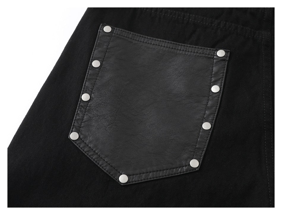 Close-up of a black garment pocket with a dark textured panel and silver snaps around the edges.