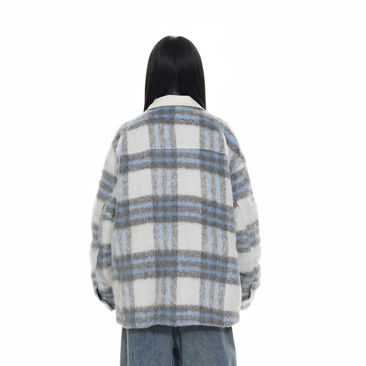 Back view of a gray, white and blue plaid jacket worn over blue jeans.