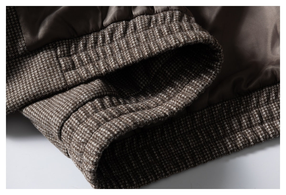 Close-up of a houndstooth jacket edge with brown lining and a folded, banded fabric finish.