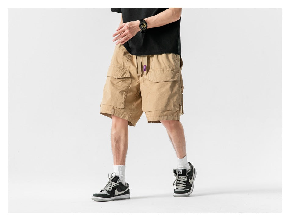 Front view of a model wearing tan cargo shorts with large flap pockets.