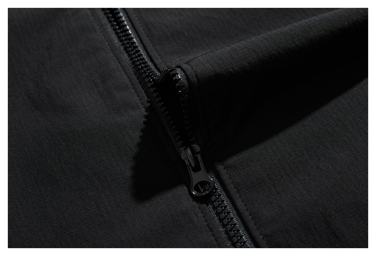 Close-up of a black jacket's front zipper and zipper pull.