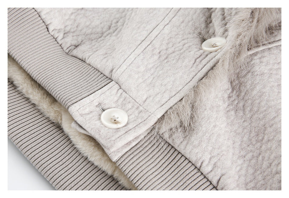 Close-up of a light beige jacket showing two buttons, ribbed trim, and fuzzy lining.