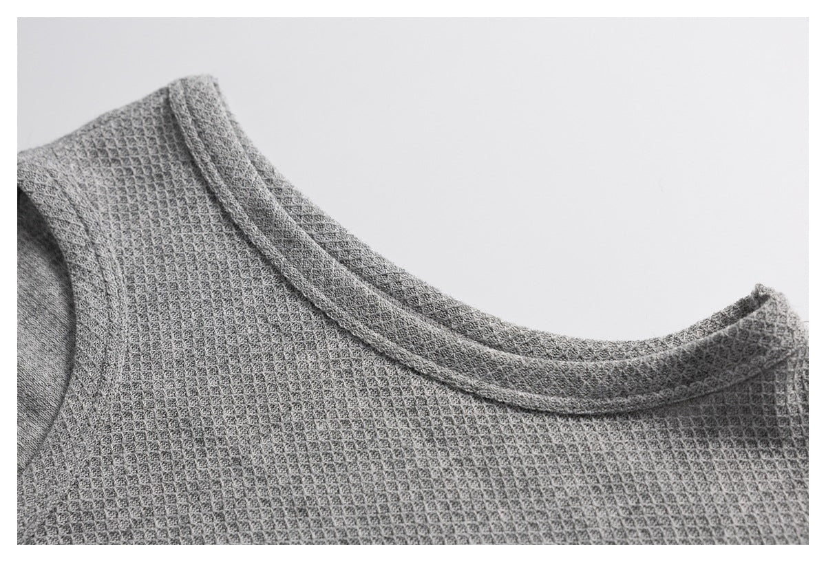 Close-up of the gray top's textured fabric and bound neckline.