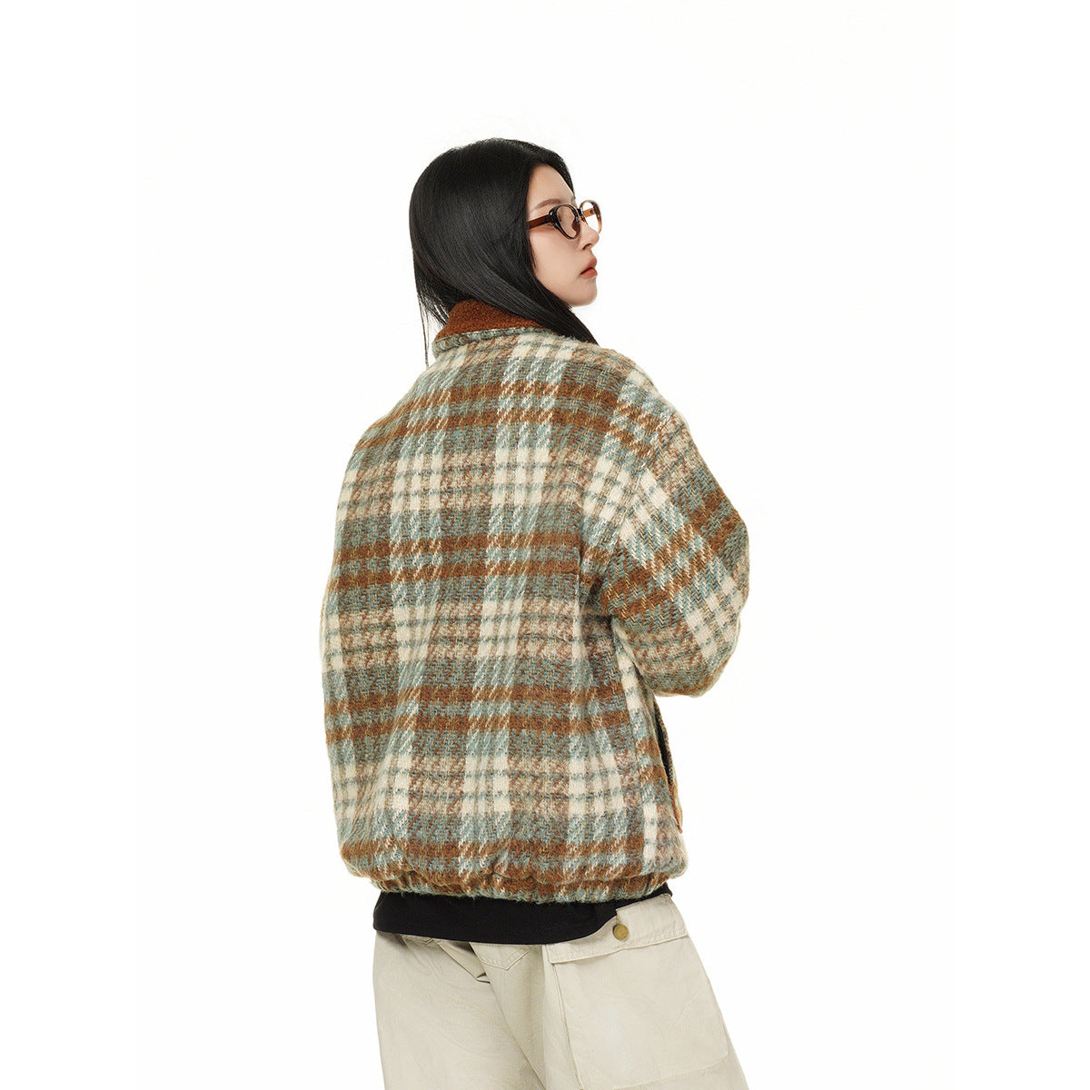 Model turned away to show the back of a cream, teal, and rust plaid jacket with a rust collar.