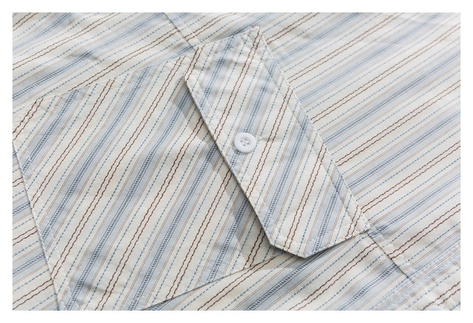 Close-up of a striped shirt chest pocket with a buttoned flap.