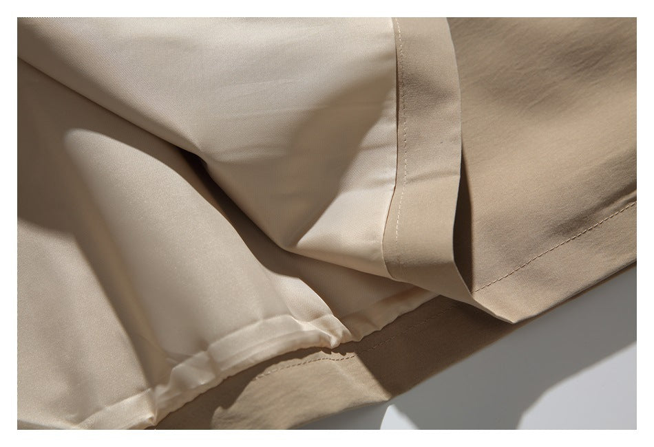 Detail of the coat's pale lining and stitched beige outer hem.