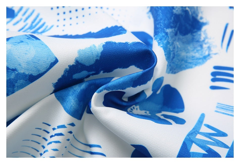 Macro view of folded white fabric with blue abstract graphics and a smooth-looking surface.