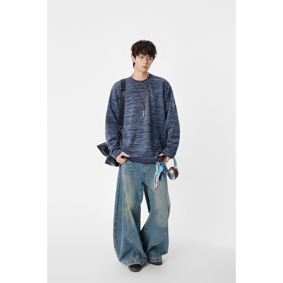 Model wearing a navy marled crewneck sweatshirt with long sleeves and a relaxed fit.