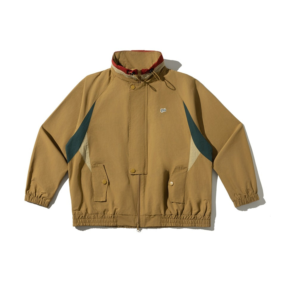 Yellow tan stand-collar zip jacket flat lay with green and cream side panels, flap pockets and elastic cuffs