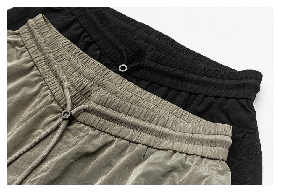 Close-up of black and taupe garments with gathered elastic waistbands and drawstrings.