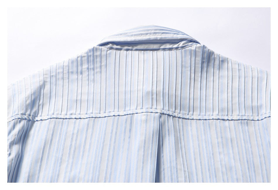 Upper back of a white shirt with narrow blue stripes, showing the yoke seam and collar.