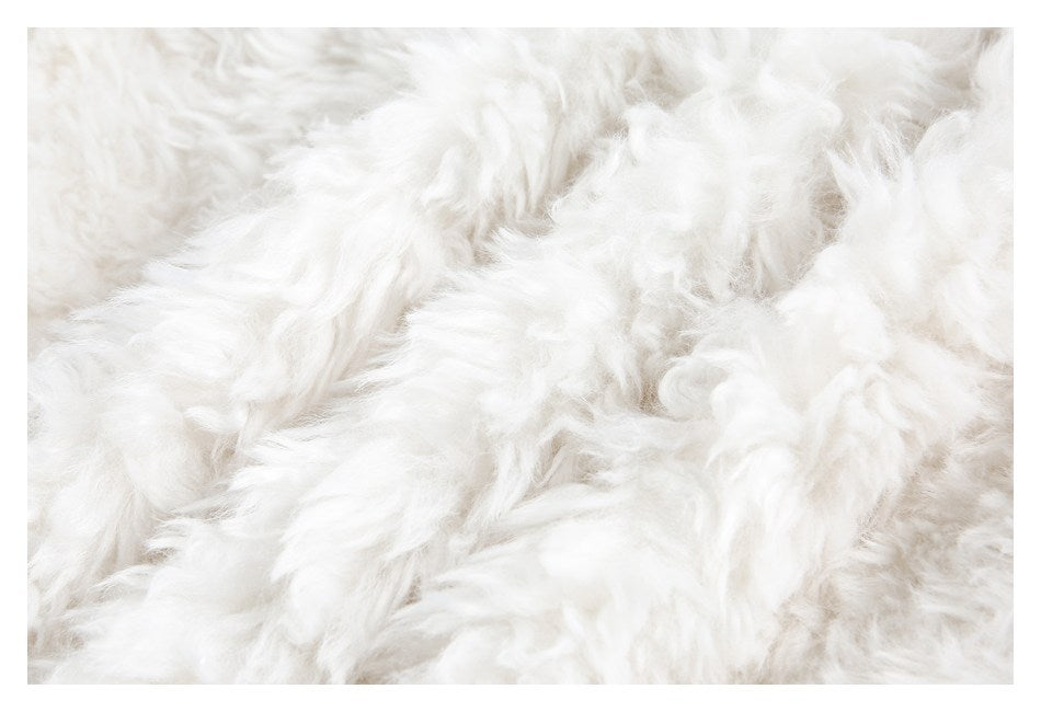 Tight close-up showing the long, fluffy white pile of the garment's trim.