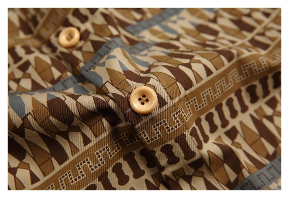 Close-up of a tan button on the shirt's brown, beige and muted blue geometric print.