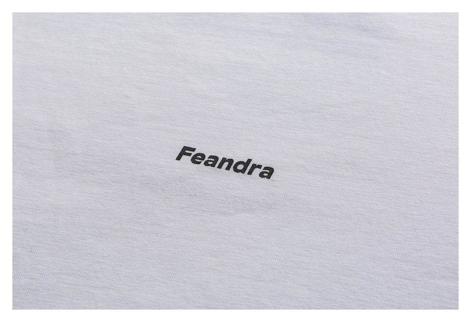 Close-up of the black Feandra wordmark printed on white T-shirt fabric.