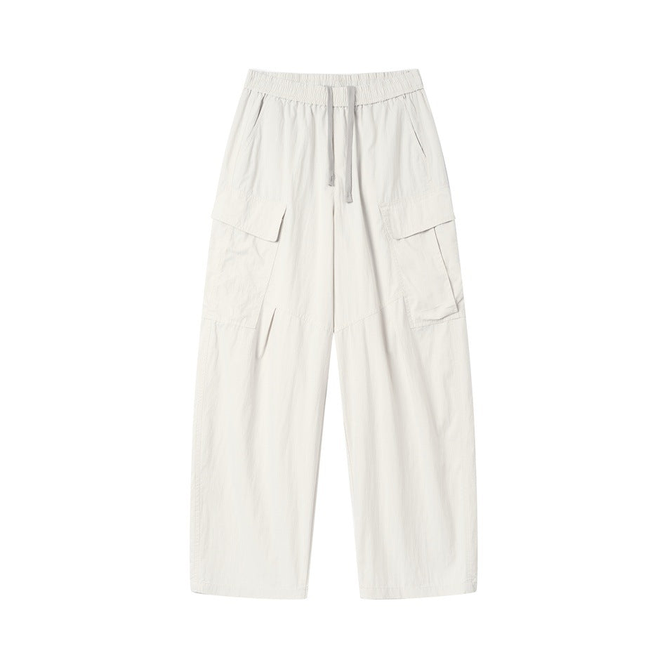 Beige wide-leg cargo pants with drawstring elastic waist and large flap thigh pockets, front flat lay