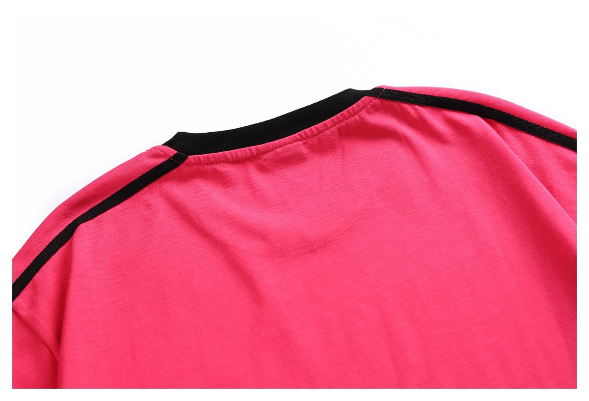 Close-up of a bright pink garment's back neckline and shoulders with black trim.