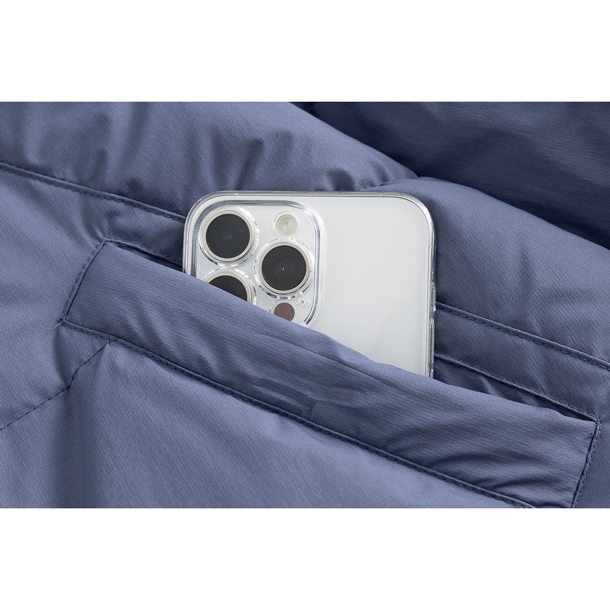 Close-up of a slate-blue jacket pocket holding a smartphone.