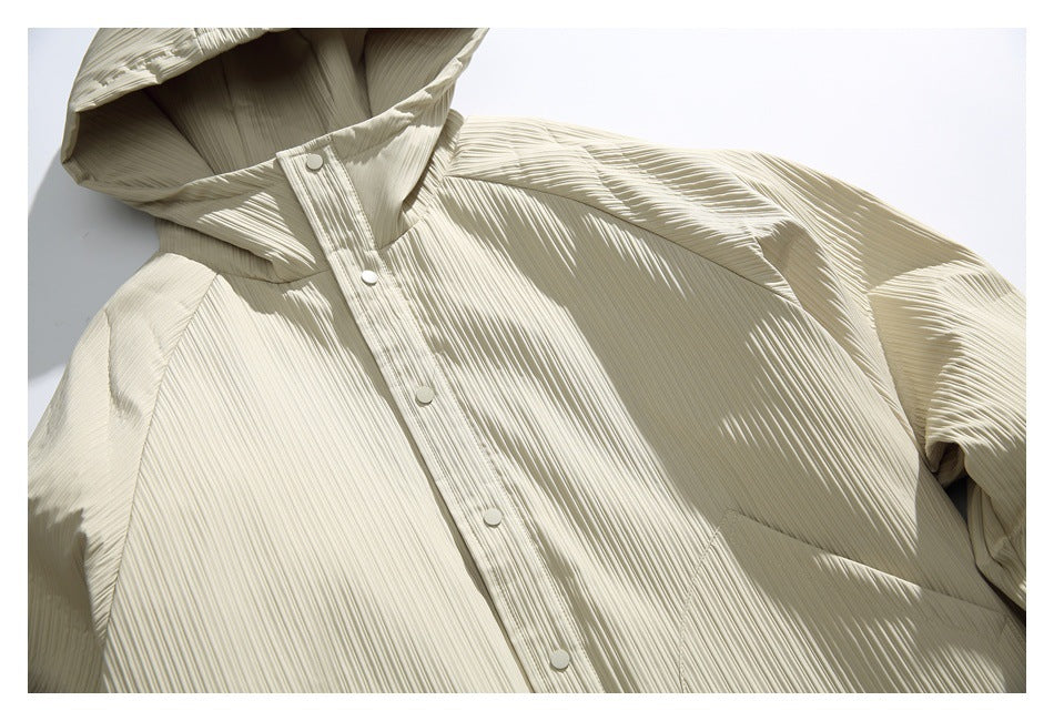 Cropped front view of an ivory finely pleated hooded jacket with snap buttons and a large front pocket.