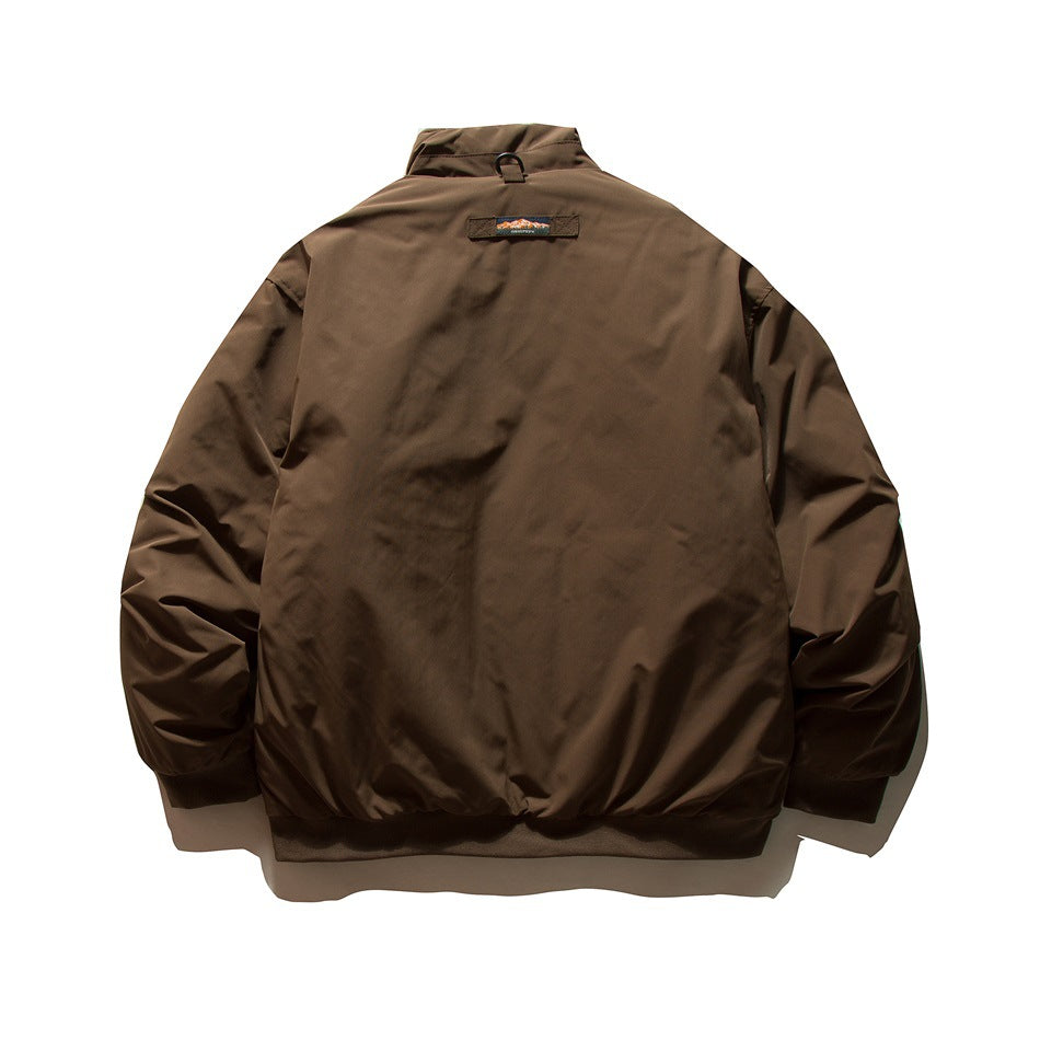 Back view of a brown jacket with a stand collar, ribbed hem and cuffs, and a small upper-back patch.