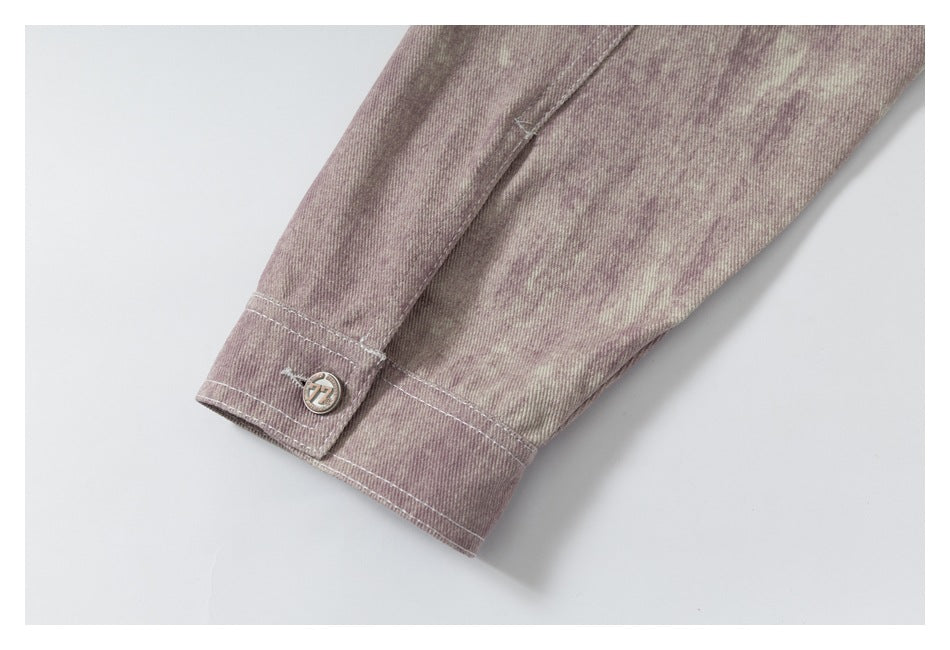 Close-up of a buttoned cuff on the mauve mottled jacket sleeve.