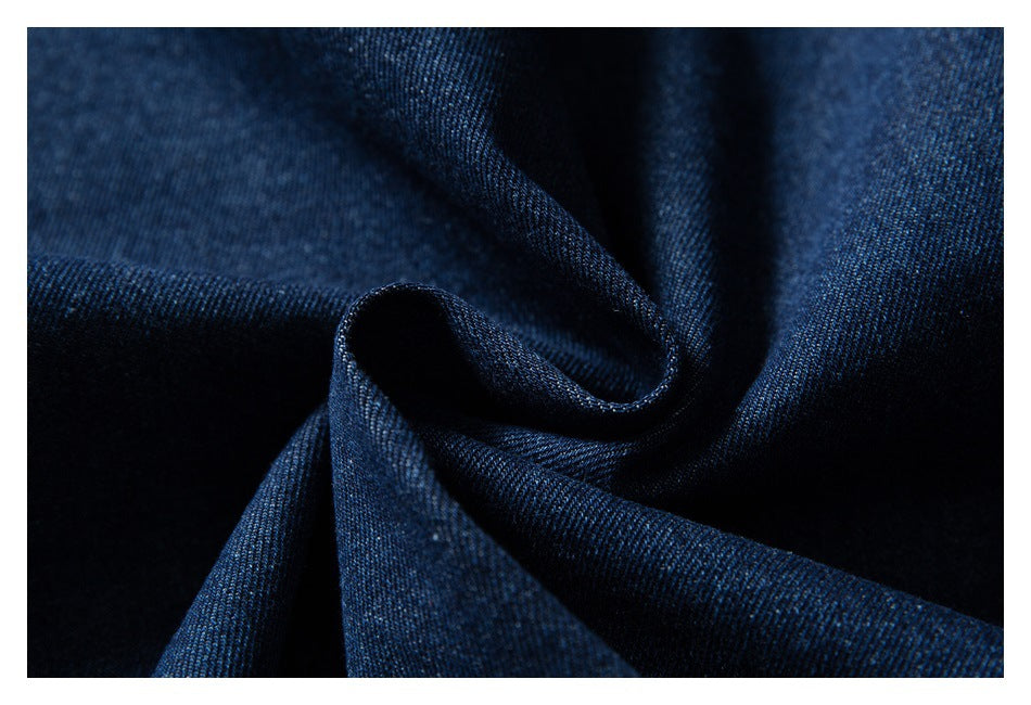 Close-up of dark indigo denim fabric gathered into soft folds.