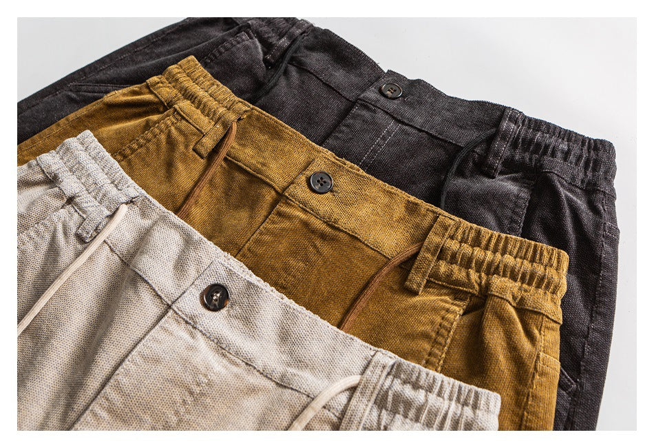 Close-up of the pants in three colors: black, mustard brown, and light beige, arranged overlapping.