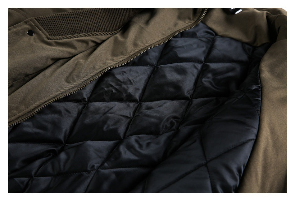 Close-up of an olive-brown jacket opened to show its black diamond-quilted lining and front zipper.