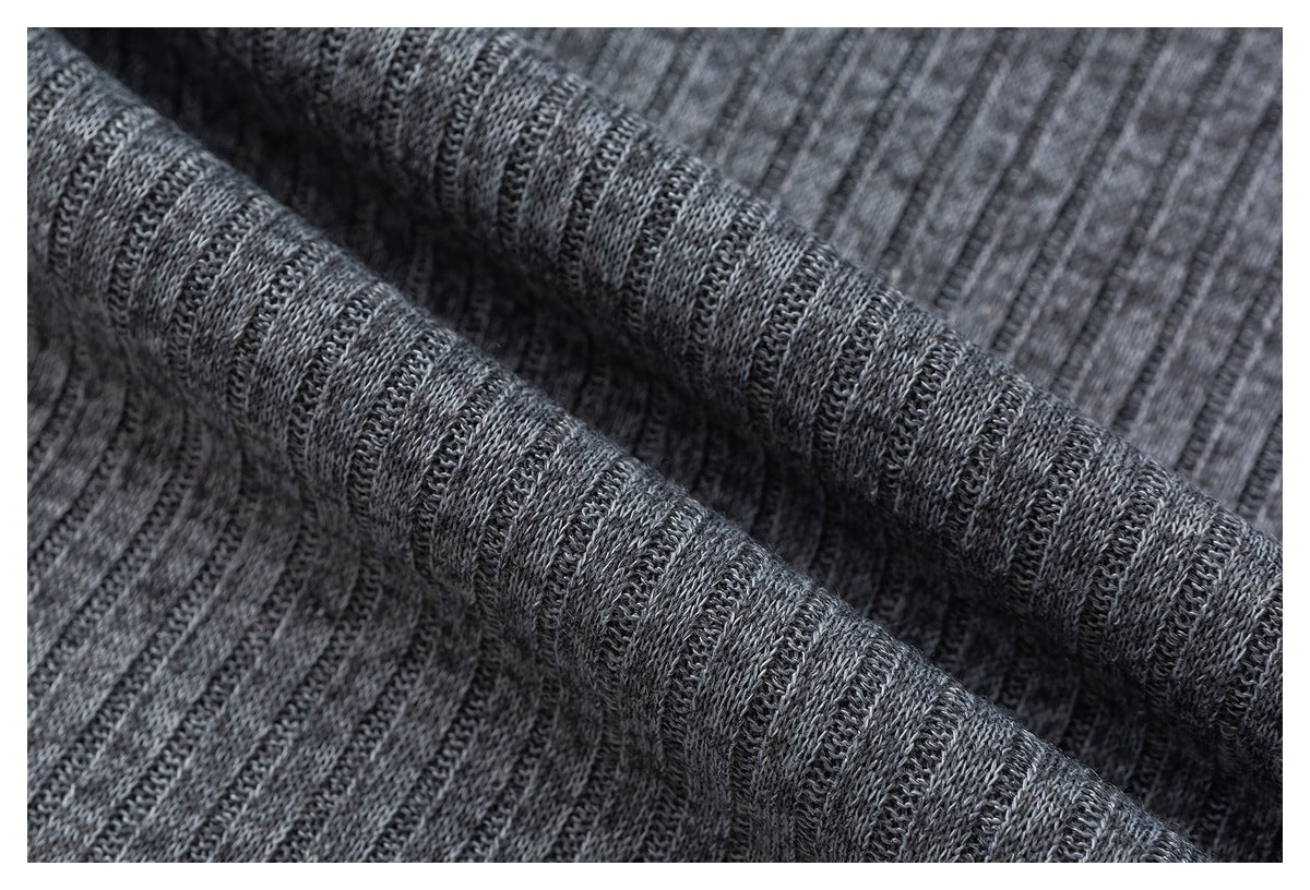 Macro view of charcoal gray knit fabric with narrow vertical textured ribs.