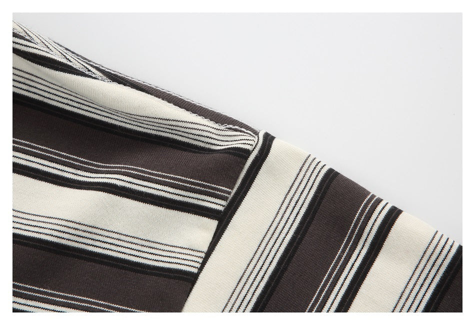 Close-up of cream and dark brown striped knit fabric with narrow black pinstripes.