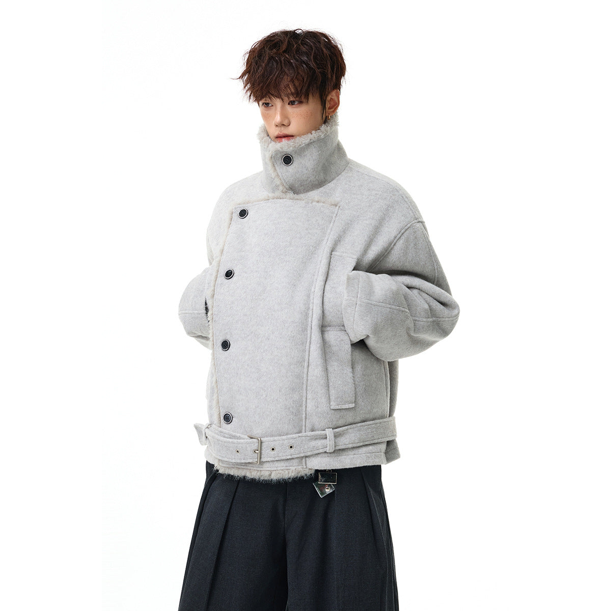 Model wearing a light gray belted jacket with a high buttoned collar and oversized sleeves.