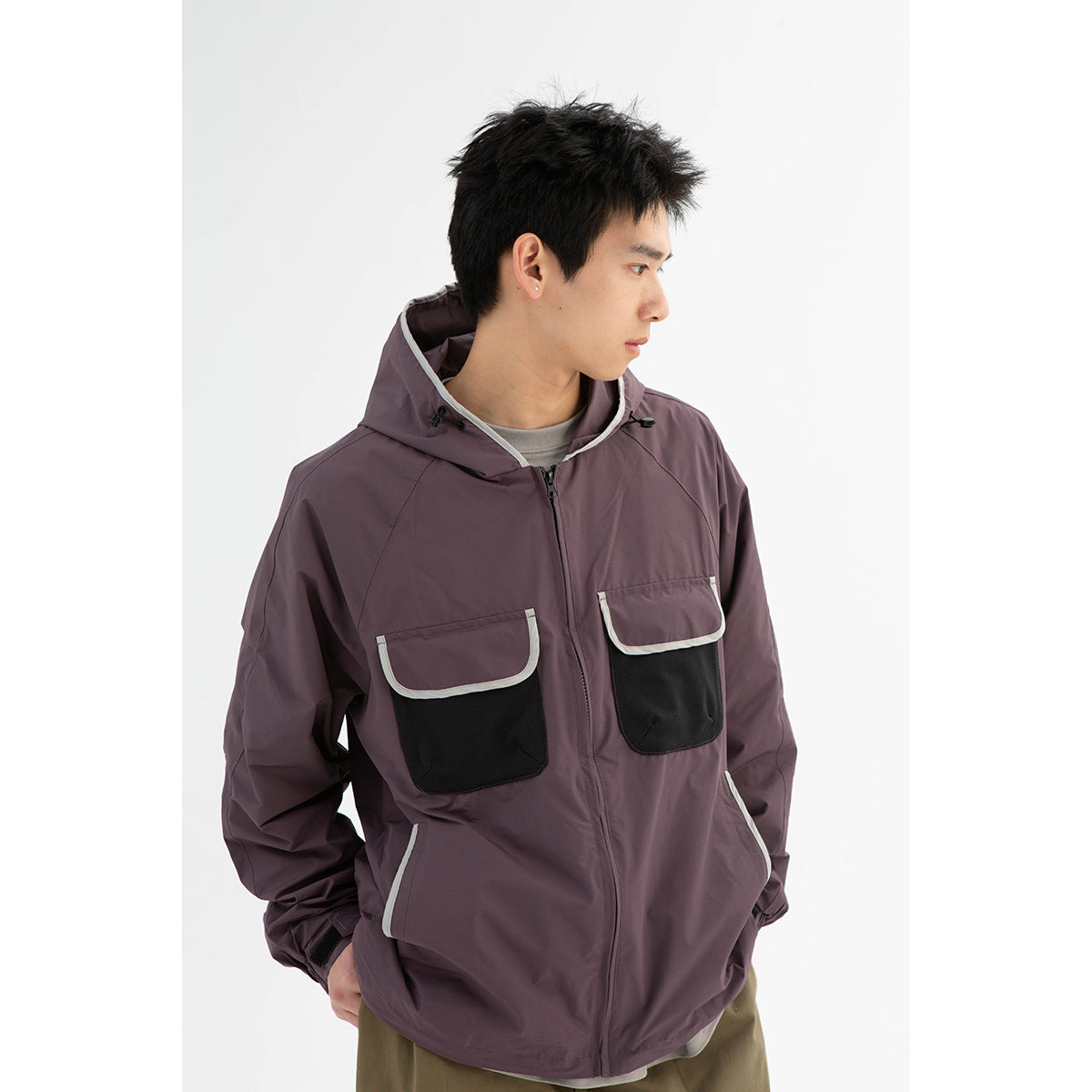 Model wearing a muted plum hooded jacket with black flap pockets and light trim, shown from the front at an angle.
