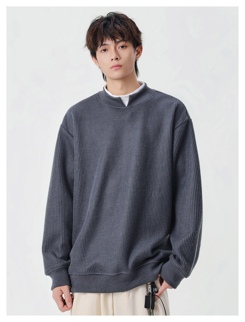 Model wearing a charcoal textured knit pullover with a split stand collar, ribbed cuffs and hem.