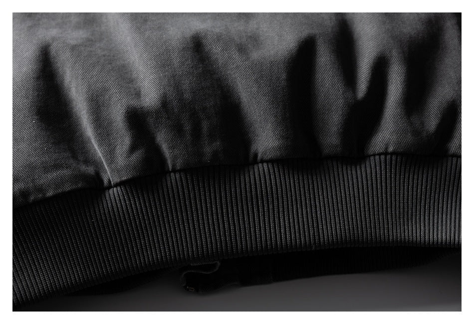 Close-up of the charcoal jacket's ribbed waistband and adjoining fabric.