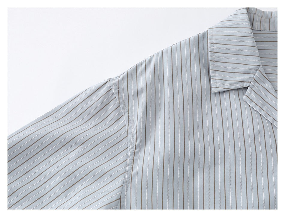 Close-up of the pinstriped shirt's short sleeve, shoulder seam, and collar edge.