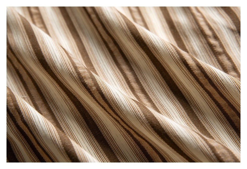 Close-up of tan, brown, and cream striped fabric gathered into soft folds.