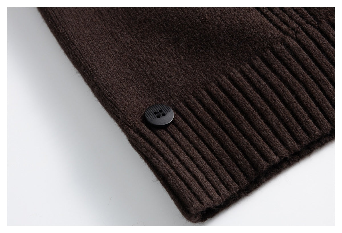 Close-up of a black button on the ribbed hem of a dark brown knit garment.
