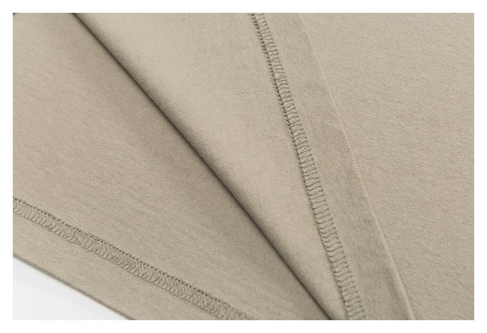 Close-up of beige garment seams with visible overlock stitching.