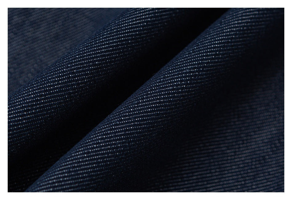 Close-up of dark navy fabric showing a fine, dotted woven texture and soft folds.